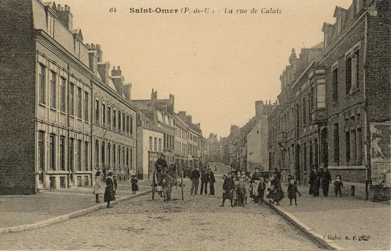 Une vue de la rue trés annimée,beaucoup d'enfants et une charrette tirée par un âne. C'est par cette rue que Louix XIV entra dans St Omer en 1677, lorsque la ville fut rattachée à son royaume.